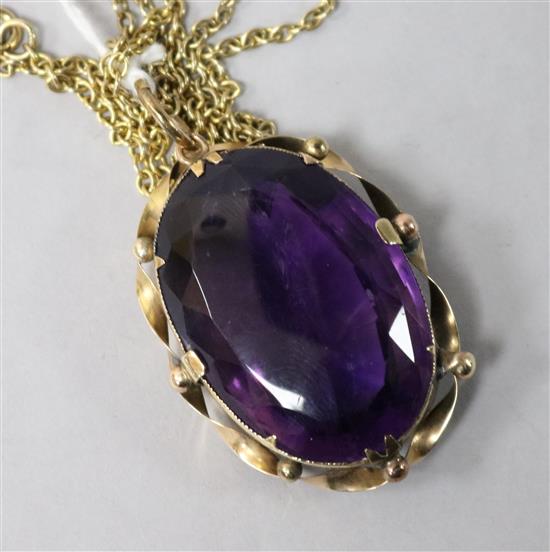A large oval facet cut amethyst pendant in yellow metal mount on 9ct gold fine link chain, pendant 44mm.